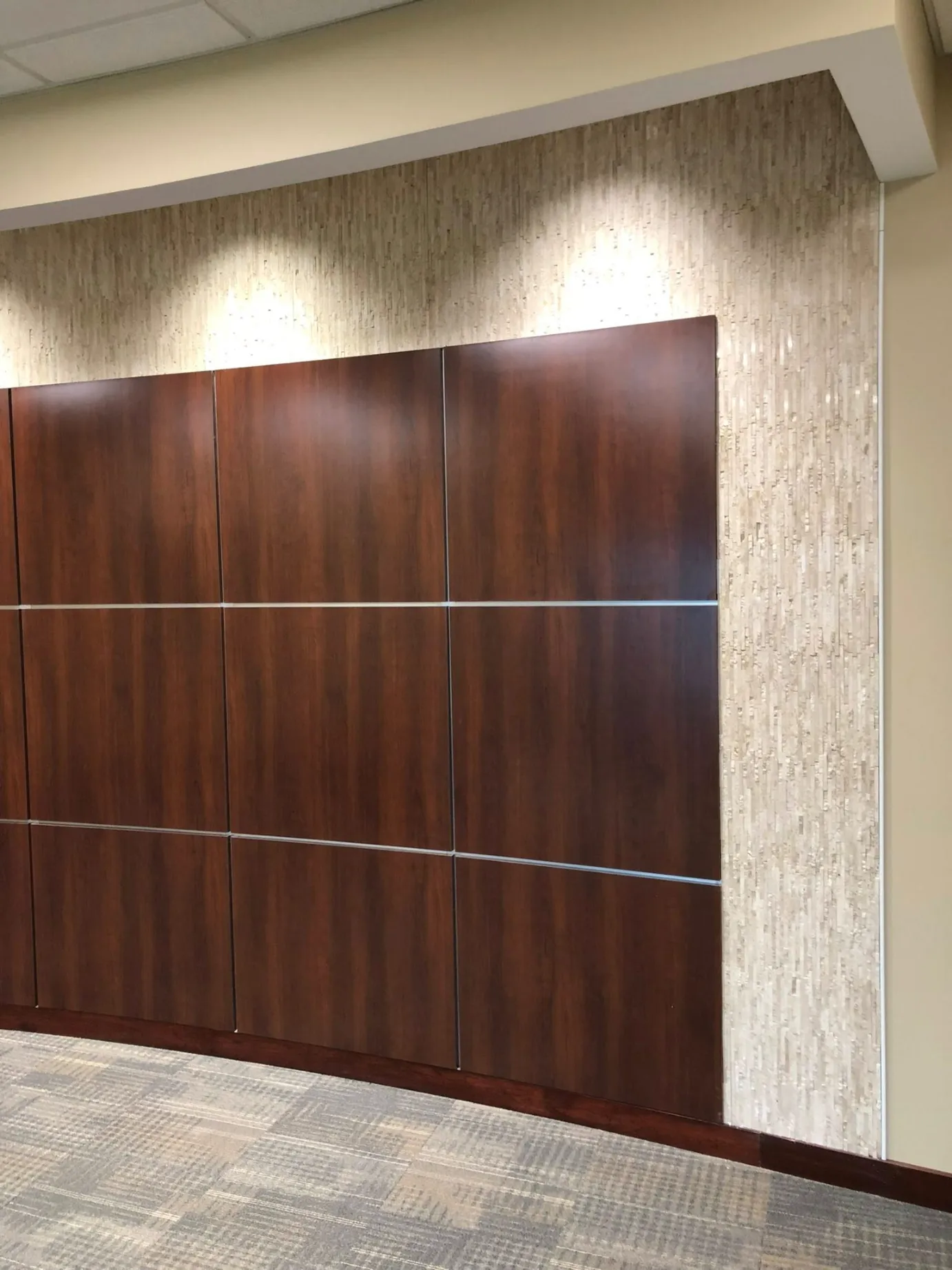 Textured ledger stone mosaic tile accent wall installation in an office lobby renovation by Dmtilellc in Middletown CT